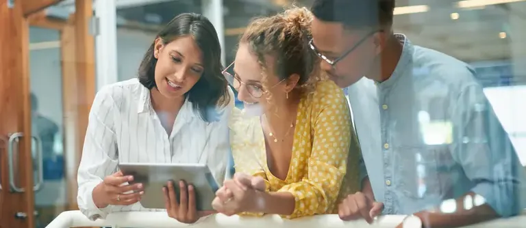Business people discussing analytics graphics in front of a tablet