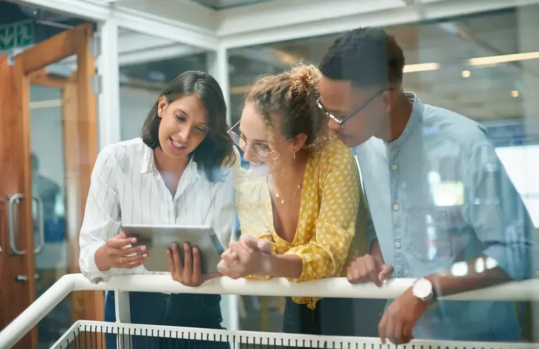 Business people discussing analytics graphics in front of a tablet