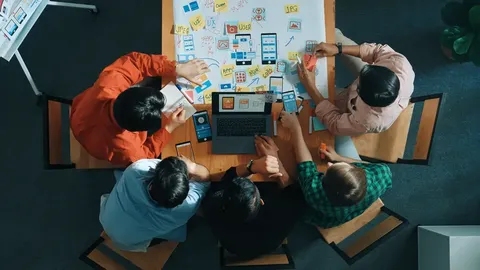 Top view of a round desk full of employees working together